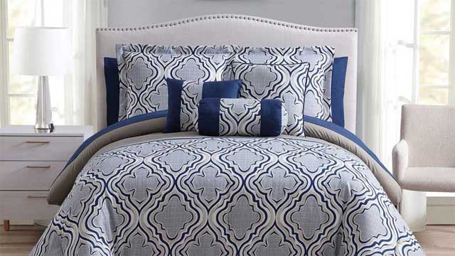 bed with blue and white printed pillow and bed sheet