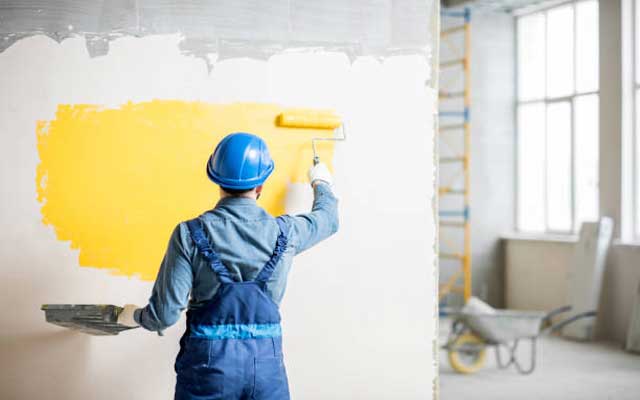 house painting by a man with blue shirt